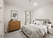 Thumbnail 11 of 39 - A bedroom with a bed, nightstand, and window.