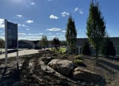 Thumbnail 37 of 43 - a landscaped area with rocks and trees in front of a building