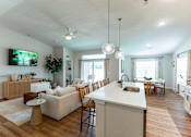 Thumbnail 4 of 29 - A modern open plan living and kitchen area with a television and a dining table.