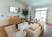 Thumbnail 3 of 29 - A living room with a white couch and a wooden coffee table.
