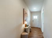Thumbnail 7 of 29 - A hallway with a bench and a painting on the wall.