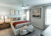 Thumbnail 8 of 29 - A bedroom with a large bed and a ceiling fan.