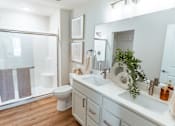 Thumbnail 10 of 29 - A white bathroom with a toilet, sink, and mirror.