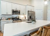 Thumbnail 1 of 29 - A kitchen with white cabinets and a white countertop.
