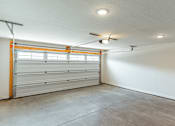 Thumbnail 14 of 29 - A garage with a white wall and a white ceiling with a fan.