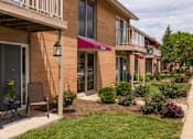 Thumbnail 13 of 13 - A row of apartment buildings with green bushes in front.