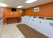 Thumbnail 11 of 13 - A laundromat with rows of washers and dryers.