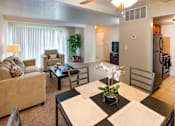 Thumbnail 2 of 13 - A living room with a couch, chair, and dining table.