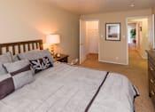 Thumbnail 6 of 13 - A bedroom with a large bed and a lamp on a side table.