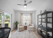 Thumbnail 6 of 17 - a living room with two chairs and a ceiling fan