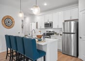 Thumbnail 3 of 17 - a kitchen with a island and a stainless steel refrigerator