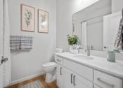 Thumbnail 12 of 17 - a bathroom with a sink and a toilet and a mirror