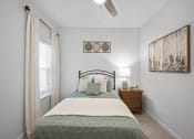 Thumbnail 11 of 17 - a bedroom with a bed and a ceiling fan