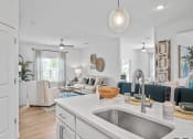 Thumbnail 5 of 17 - a kitchen with a sink and a view of a living room