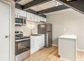Thumbnail 1 of 27 - A kitchen with white cabinets and stainless steel appliances.
