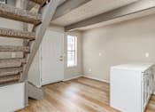 Thumbnail 12 of 27 - A room with a staircase and a white cabinet.