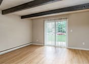 Thumbnail 16 of 27 - A room with wooden floors and a sliding glass door.