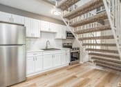 Thumbnail 2 of 27 - A kitchen with a staircase leading to the upper floor.