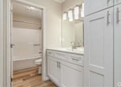 Thumbnail 23 of 27 - A white bathroom with a tub, toilet, and sink.