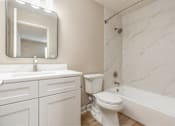 Thumbnail 7 of 27 - A white bathroom with a marble wall and a mirror above the sink.