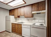 Thumbnail 8 of 21 - A kitchen with white appliances and wooden cabinets.