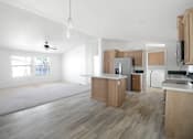 Thumbnail 2 of 9 - A kitchen with wooden cabinets and a white ceiling.