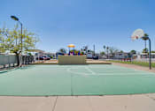 Thumbnail 9 of 10 - A basketball court with a green surface and a white hoop.