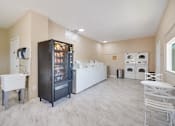 Thumbnail 10 of 10 - A kitchen with a black fridge and white cabinets.