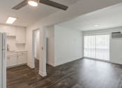 Thumbnail 6 of 28 - an empty living room with a kitchen in the background