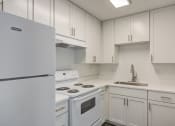 Thumbnail 5 of 28 - a kitchen with white cabinets and white appliances