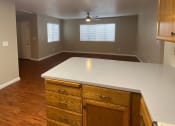 Thumbnail 10 of 11 - an empty kitchen with a white counter top and wooden floors