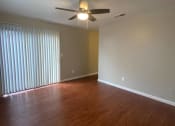 Thumbnail 11 of 11 - an empty living room with wood floors and a ceiling fan