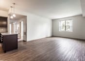 Thumbnail 15 of 16 - A large empty room with wooden floors and a window.
