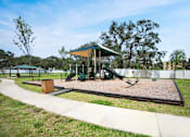 Thumbnail 10 of 14 - A playground with a green canopy and a slide.