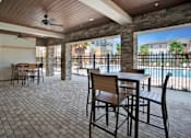 Thumbnail 13 of 17 - a patio with tables and chairs and a pool in the background