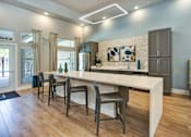 Thumbnail 14 of 14 - A modern kitchen with a long island and chairs.
