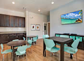 Thumbnail 16 of 17 - a room with a table and chairs and a flat screen tv on the wall