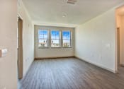 Thumbnail 6 of 14 - A room with a window overlooking a building.