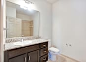 Thumbnail 4 of 14 - A bathroom with a sink, toilet and mirror.