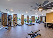 Thumbnail 8 of 9 - A spacious gym with a variety of equipment including treadmills, weights, and a bench press.