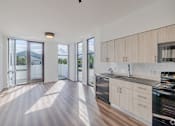 Thumbnail 7 of 9 - A modern kitchen with wooden cabinets and a stainless steel dishwasher.