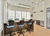 Thumbnail 10 of 20 - a room with a long counter with four blue chairs in front of it