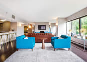 Thumbnail 16 of 26 - Seating area with two blue seats and a leather couch in the clubhouse  at Prospect Place, Hackensack, NJ