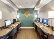 Thumbnail 20 of 26 - Several computers and desks in the well lit business center at Prospect Place, NJ 07601