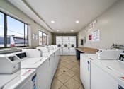 Thumbnail 12 of 14 - A row of washing machines in a laundromat.