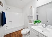 Thumbnail 8 of 12 - A white bathroom with a toilet, sink, and shower.