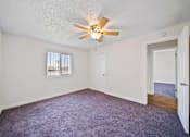 Thumbnail 9 of 12 - A room with a ceiling fan and a window with blinds.