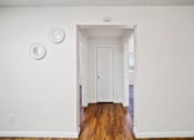 Thumbnail 4 of 12 - A white door is in a white room with a light switch on the wall.
