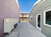 Thumbnail 10 of 12 - A building with a pink wall and a white door.