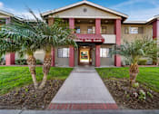 Thumbnail 5 of 8 - The front of a building with a red brick pathway leading to the entrance.